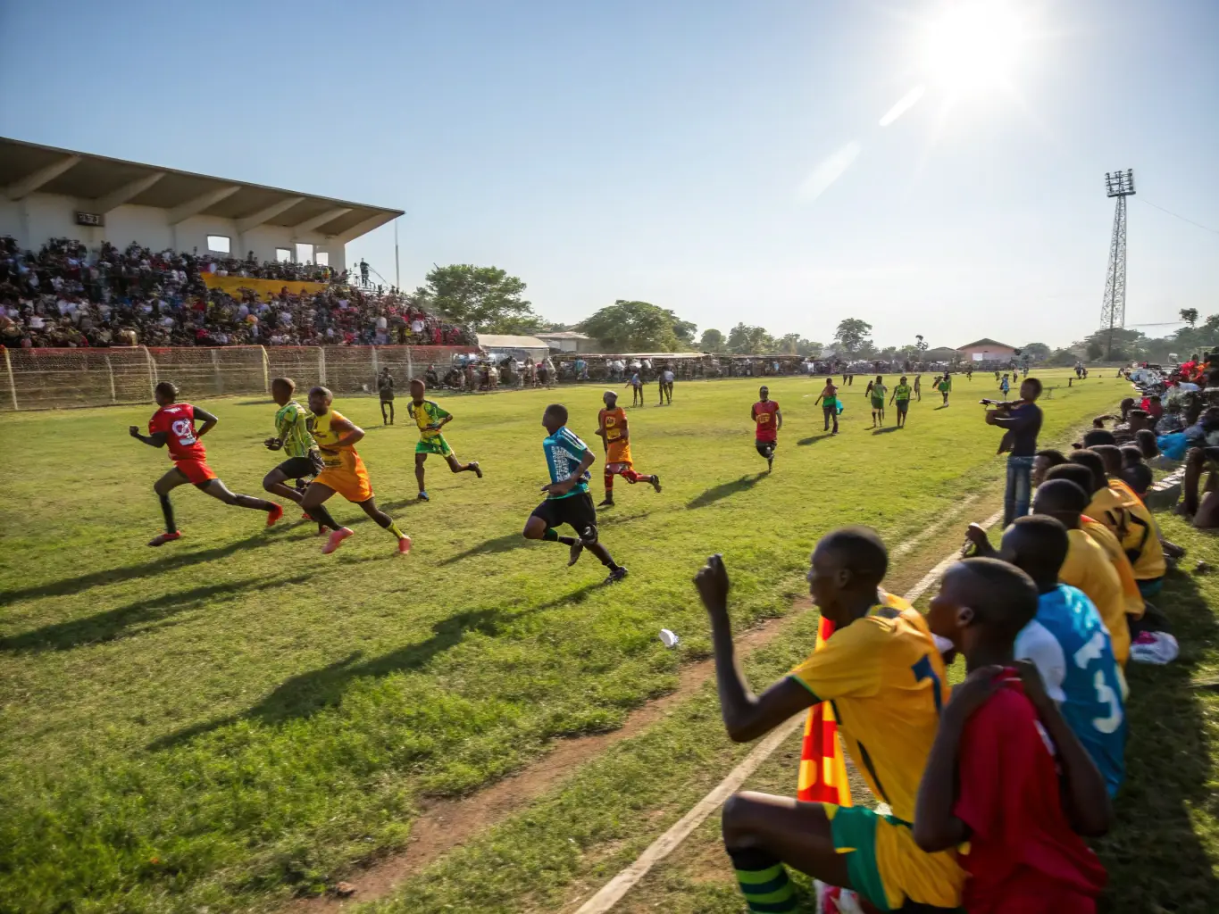 A dynamic shot of athletes competing in a local sports event, capturing the excitement and competitive spirit, with spectators cheering in the background.
